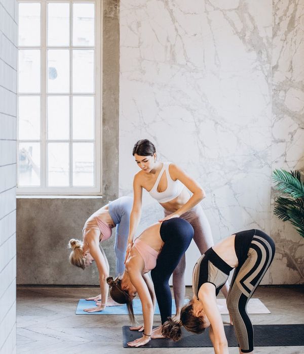 Person stretching on a yoga mat in a brightly lit room.